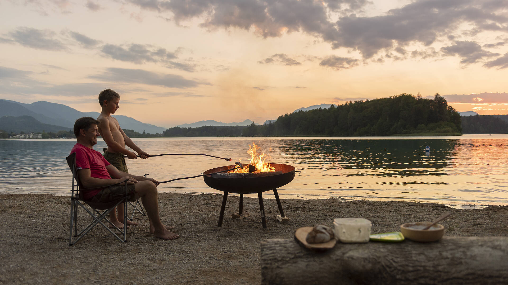 Vater und Sohn beim Würstelgrillen am Campingplatz 